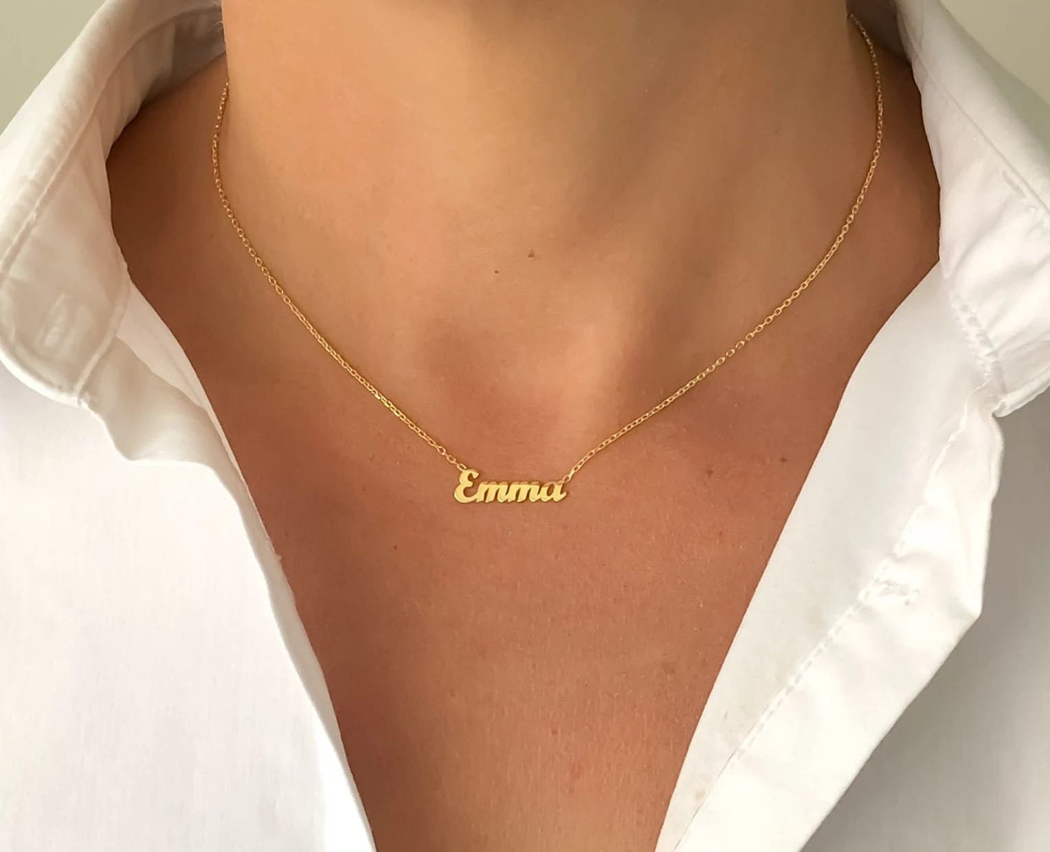 Woman wearing delicate gold script name necklace