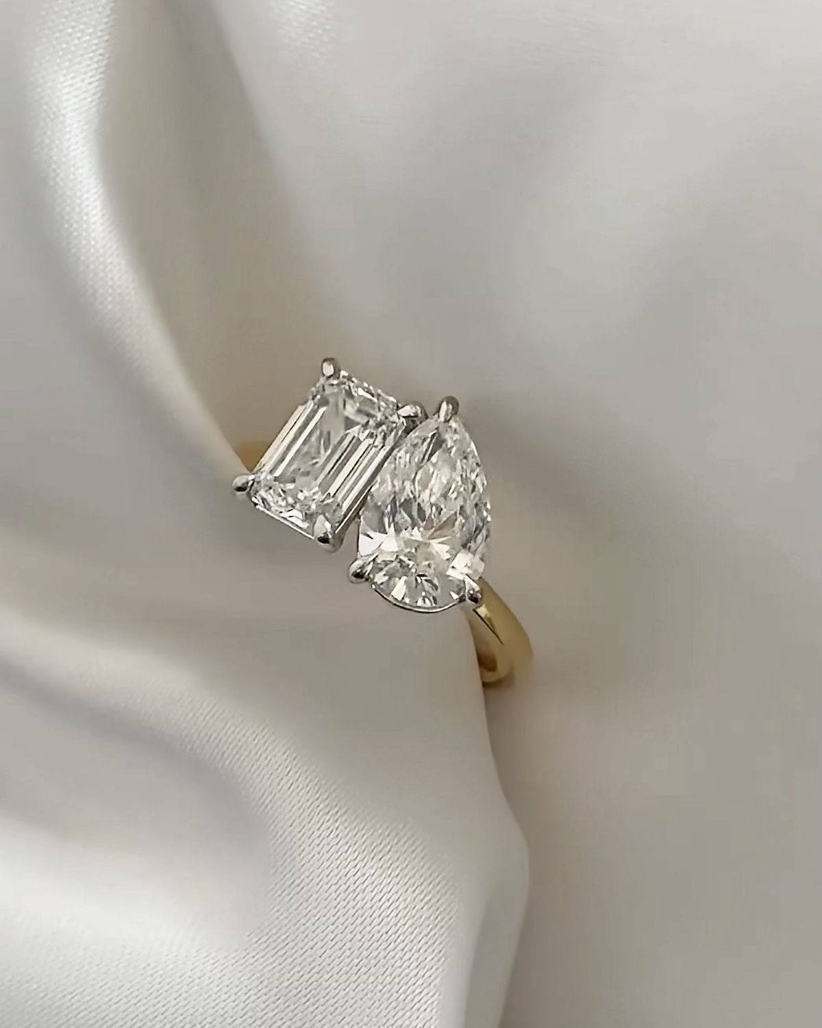 AI-generated toi et moi ring with emerald and diamond in bypass pave gold setting